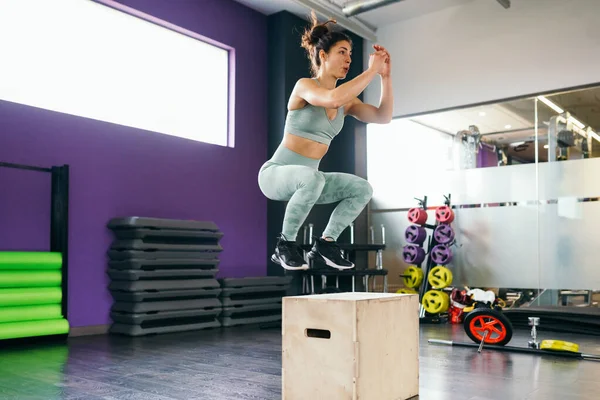Καυκάσια γυναίκα κάνει το άλμα κουτί προπόνηση στο γυμναστήριο. — Φωτογραφία Αρχείου