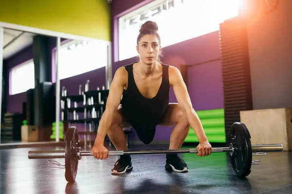 Mujer atlética en gimnasia levantando pesas en el gimnasio —  Fotos de Stock