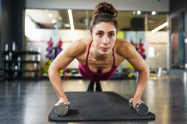 Woman doing push-ups exercise with dumbbell in a fitness workout — Stock Photo, Image