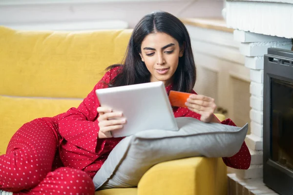 Persian woman at home using digital tablet