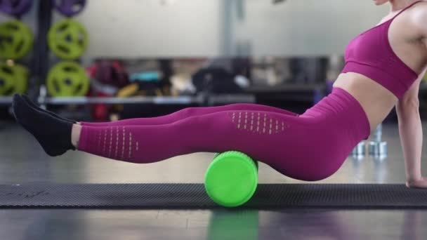 Vrouw ontspannen haar been spieren met een groene schuim roller — Stockvideo