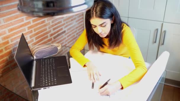 Female architect working at home with a laptop and blueprints — Stock Video