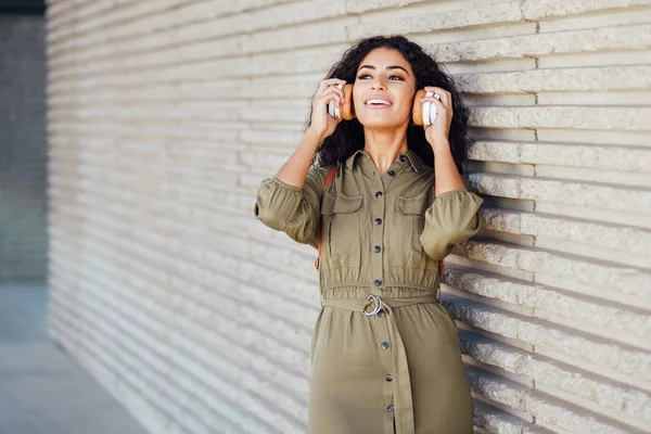 Jonge Arabische vrouw loopt op straat met een draadloze hoofdtelefoon — Stockfoto