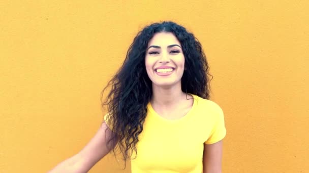 Fiatal arab alkalmi nő a sárga falon az utcán mosolyogva és nevetve. — Stock videók