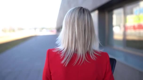 Empresaria de mediana edad caminando fuera de un edificio de oficinas . — Vídeos de Stock