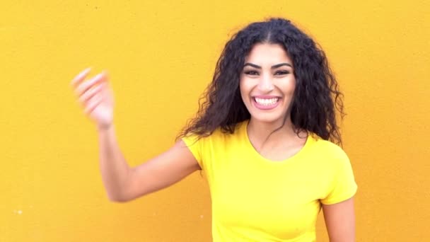 若いですアラブカジュアル女性上の黄色の壁に路上で笑顔と笑い. — ストック動画