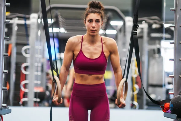 Atletische vrouw doen sommige pull-up oefeningen in de gymnastische ringen — Stockfoto