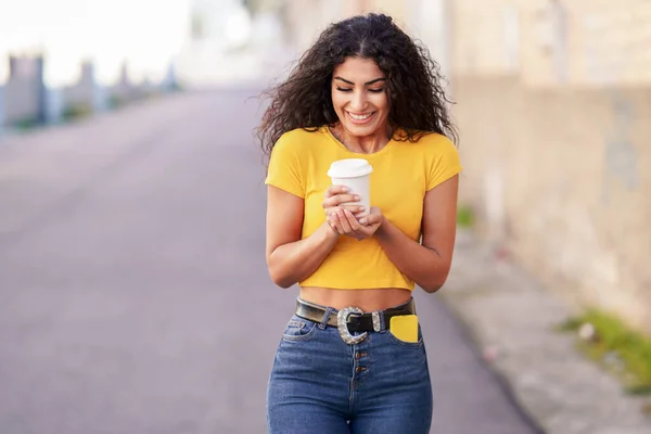 Chica árabe caminando por la calle con un café para llevar — Foto de Stock