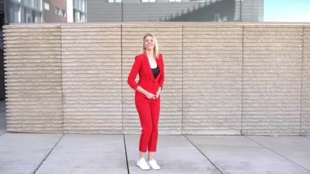 Geschäftsfrau mittleren Alters springt aus einem Bürogebäude. — Stockvideo