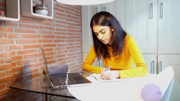 Vrouwelijke architect werkt thuis met een laptop en blauwdrukken — Stockvideo