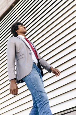 Black Businessman wearing suit walking in urban background.