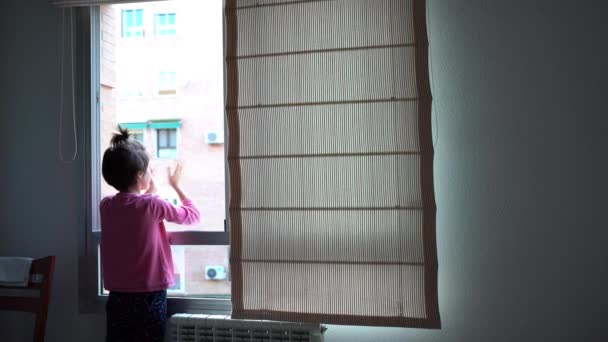 Chica aplaudiendo en la ventana en apoyo de las personas que luchan contra el coronavirus — Vídeo de stock