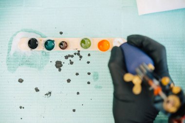 Dövmeli kadın dövme makinesini mürekkeple dolduruyor..