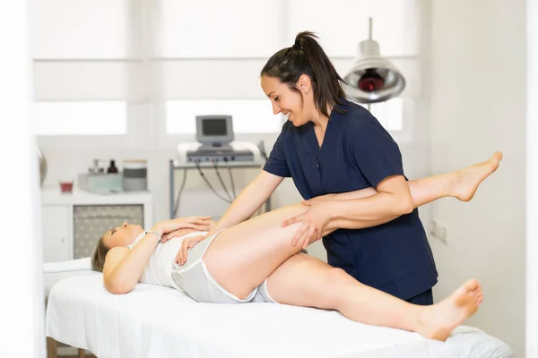 Fisioterapeuta inspeccionando a su paciente en un centro de fisioterapia . —  Fotos de Stock