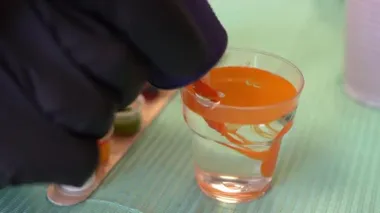Dövmeci kadın dövme makinesini suyla temizliyor..