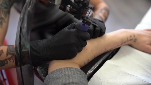 Női tetováló tetováló barackot tetovál egy nő karjára.. — Stock videók