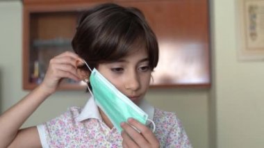 Koronavirüsten korunmak için evde maske takan bir kız..