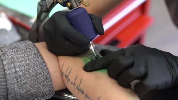 Mujer tatuadora tatuando un melocotón en un brazo de mujer. — Vídeos de Stock