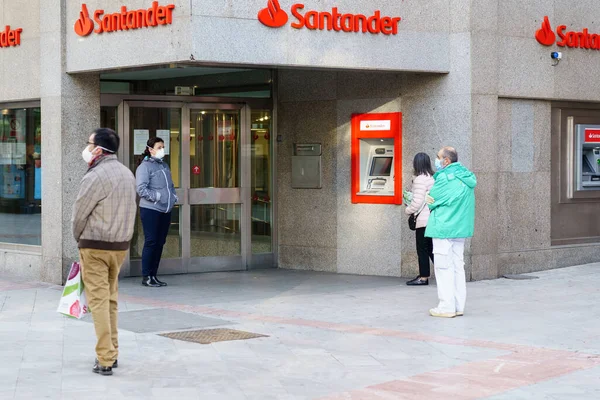 GRANADA, SPAIN, 23RD APRIL, 2020 Люди, стоящие в очереди в банке под масками . — стоковое фото