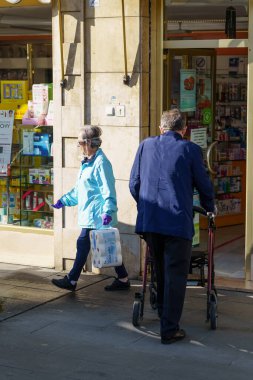 GANADA SPAIN 23RD Nisan 2020 Eczaneden alışveriş yapan yaşlı insanlar, maskeler tarafından korunuyor