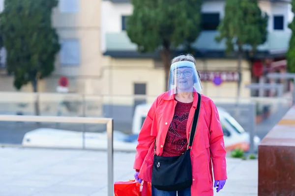 GRANADA SPANJE 23RD APRIL 2020 Oudere vrouw winkelen in de stad beschermd door een masker. — Stockfoto