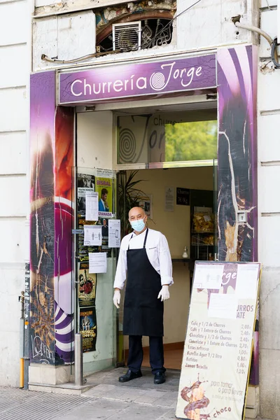 GRANADA, ESPAÑA, 23RD ABRIL, 2020 Cocinar una tienda de churros de pie en la puerta de su tienda, con una máscara — Foto de Stock