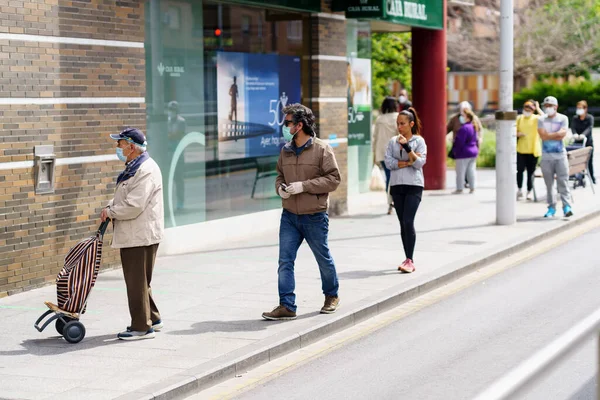 GRANADA, ESPAÑA, 23RD ABRIL, 2020 Personas haciendo cola en el supermercado protegidas por máscaras . — Foto de Stock