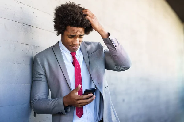 Worried Black Businessman using his smartphone outdoors. — Stock Photo, Image