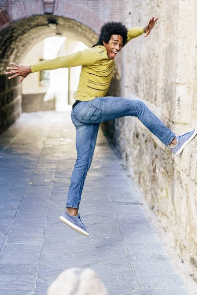 Schwarzer Mann mit Afro-Haaren springt vor Freude — Stockfoto