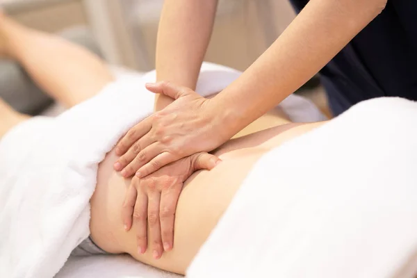 Jeune femme recevant un massage du dos dans un centre de physiothérapie — Photo