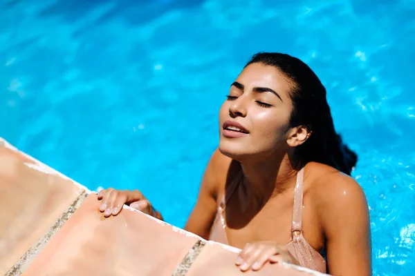 Vacker arabisk kvinna avkopplande i poolen. — Stockfoto