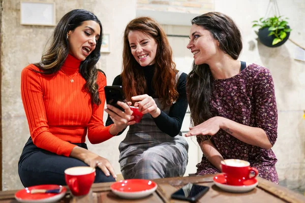 Groep van drie gelukkige vrienden die koffie drinken in een café bar. — Stockfoto
