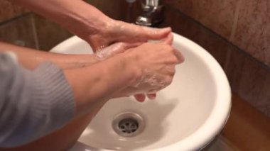 Anne, Coronavirüs salgınını önlemek için ellerini yıkıyor.