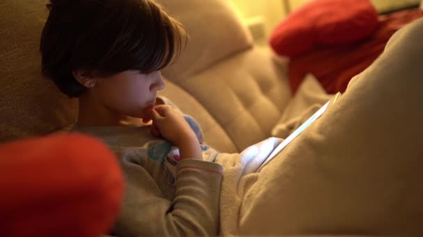 Dokuz yaşında bir kız e-kitapta hikaye okuyor. — Stok video