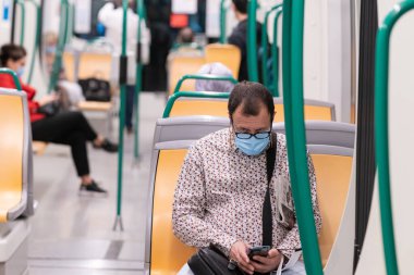 Granada, İspanya, 4 Mayıs 2020 Covid-19 salgını sırasında trende cerrahi maske takan insanlar