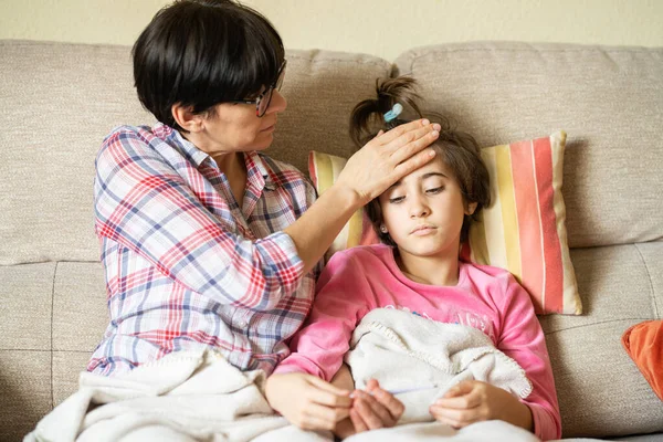 Mãe medindo a temperatura de suas filhas para verificar se há febre — Fotografia de Stock