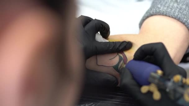 Mujer tatuadora tatuando un melocotón en un brazo de mujer. — Vídeos de Stock