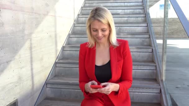Bizneswoman w średnim wieku za pomocą smartfona na zewnątrz. — Wideo stockowe
