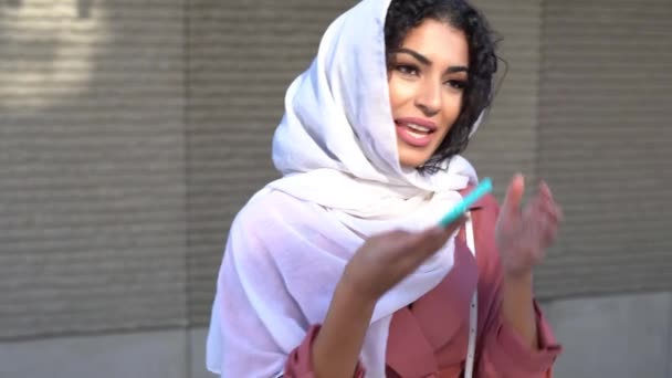 Νεαρή Μουσουλμάνα γυναίκα που φοράει μαντίλα στέλνει μήνυμα με το smartphone της. — Αρχείο Βίντεο