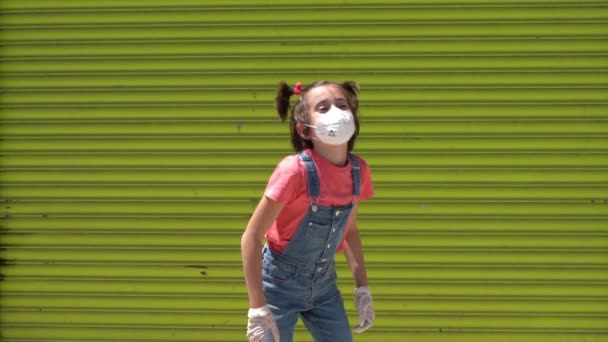 Barn flicka hoppning bär en skyddsmask mot coronavirus — Stockvideo
