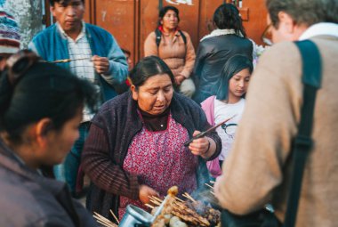 Woman Grilling Anticucho Skewers in Peru