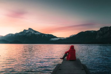 Avustralya 'da bir göldeki iskelede gün doğumu ve dağların manzarası.