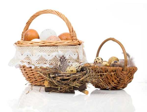 Cesta con huevos y huevos de codorniz sobre un fondo blanco — Foto de Stock