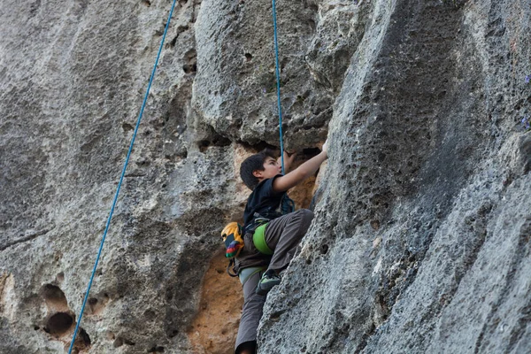 Boy climbing on a limestone wall — Stock Photo, Image