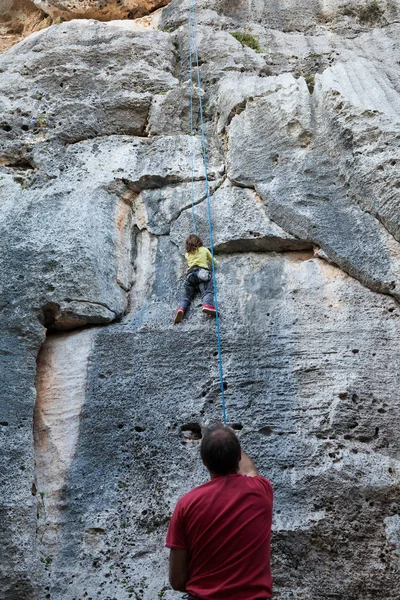 Little girl climbing on a limestone wall — Stock Photo, Image