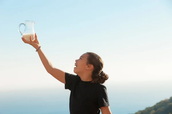 Girl with a jug of milk in hand — Stock Photo, Image