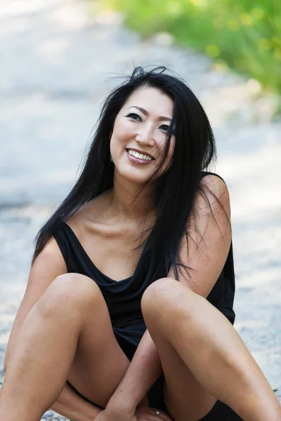 Asian woman sitting cross-legged in the street — Stock Photo, Image