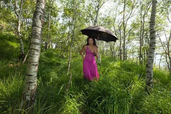 Mujer caminando en el bosque con paraguas negro — Foto de Stock