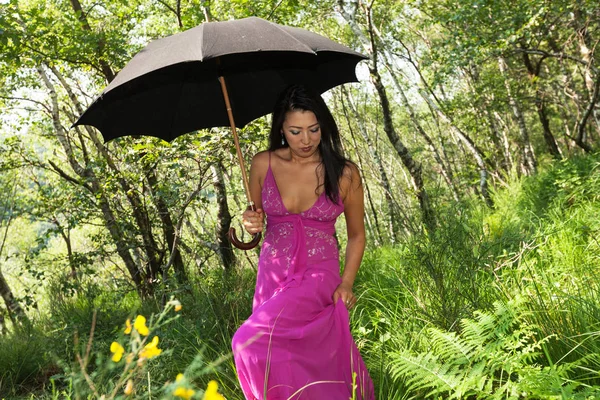 Mujer caminando en el bosque con paraguas negro — Foto de Stock