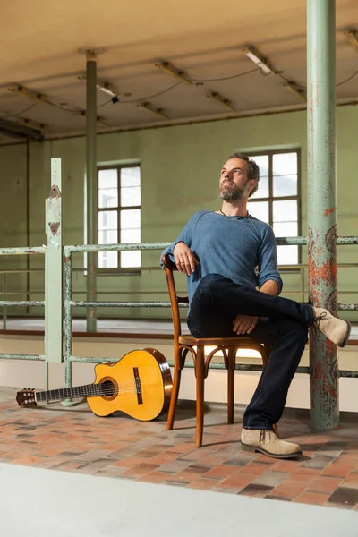 Retrato de hombre con guitarra, la ubicación industrial — Foto de Stock